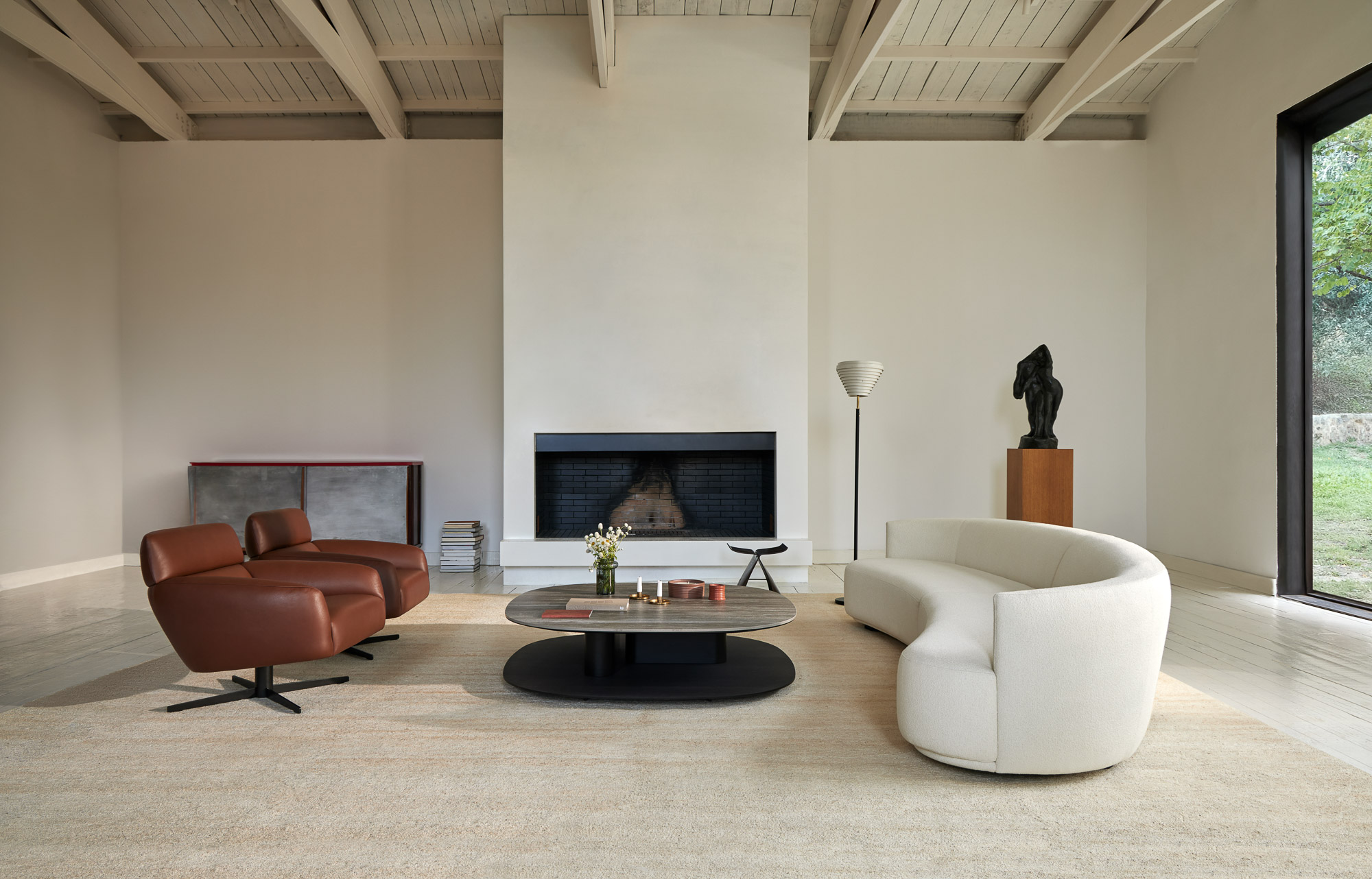 Flow curved sofa system, Sacha SE coffee table, and Ethos lounge chair designed by Mario Ruiz for Joquer